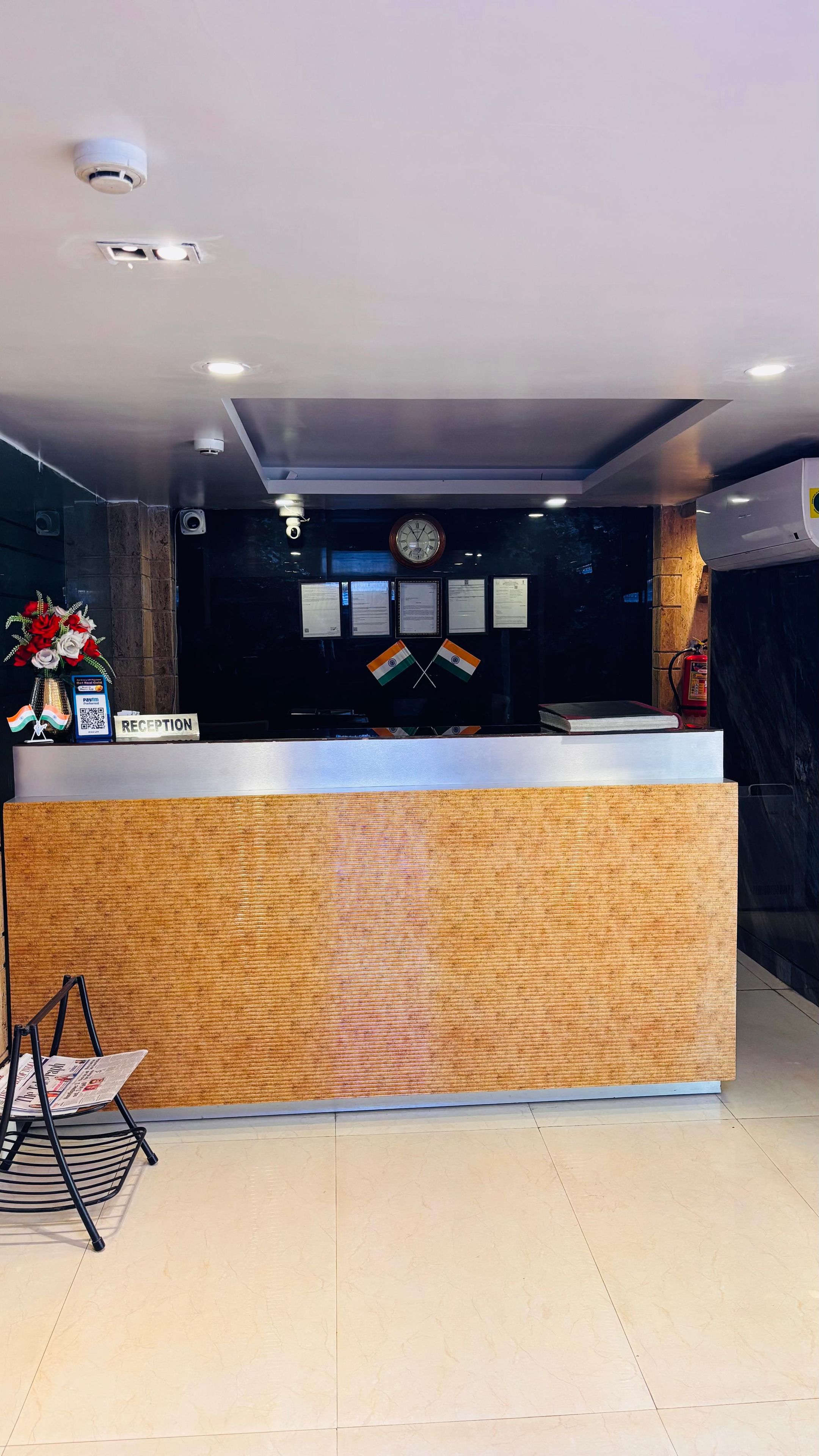 A reception desk with a clock, framed certificates, and a fire extinguisher.