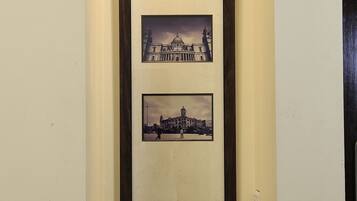 A framed photograph of a historic building, a coffee maker, and cups on a tray.