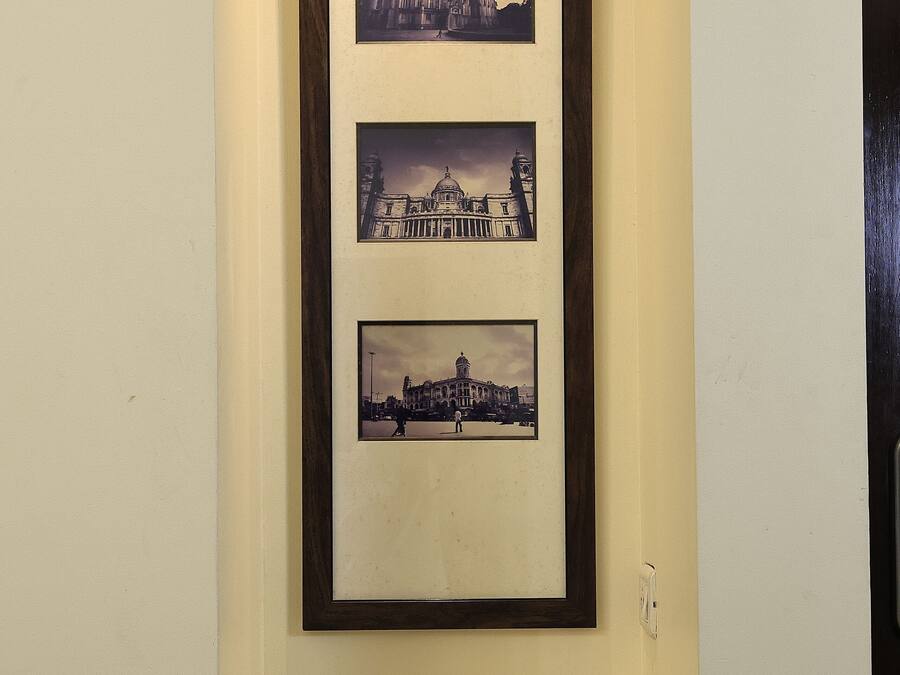 A framed photograph of a historic building, a coffee maker, and cups on a tray.