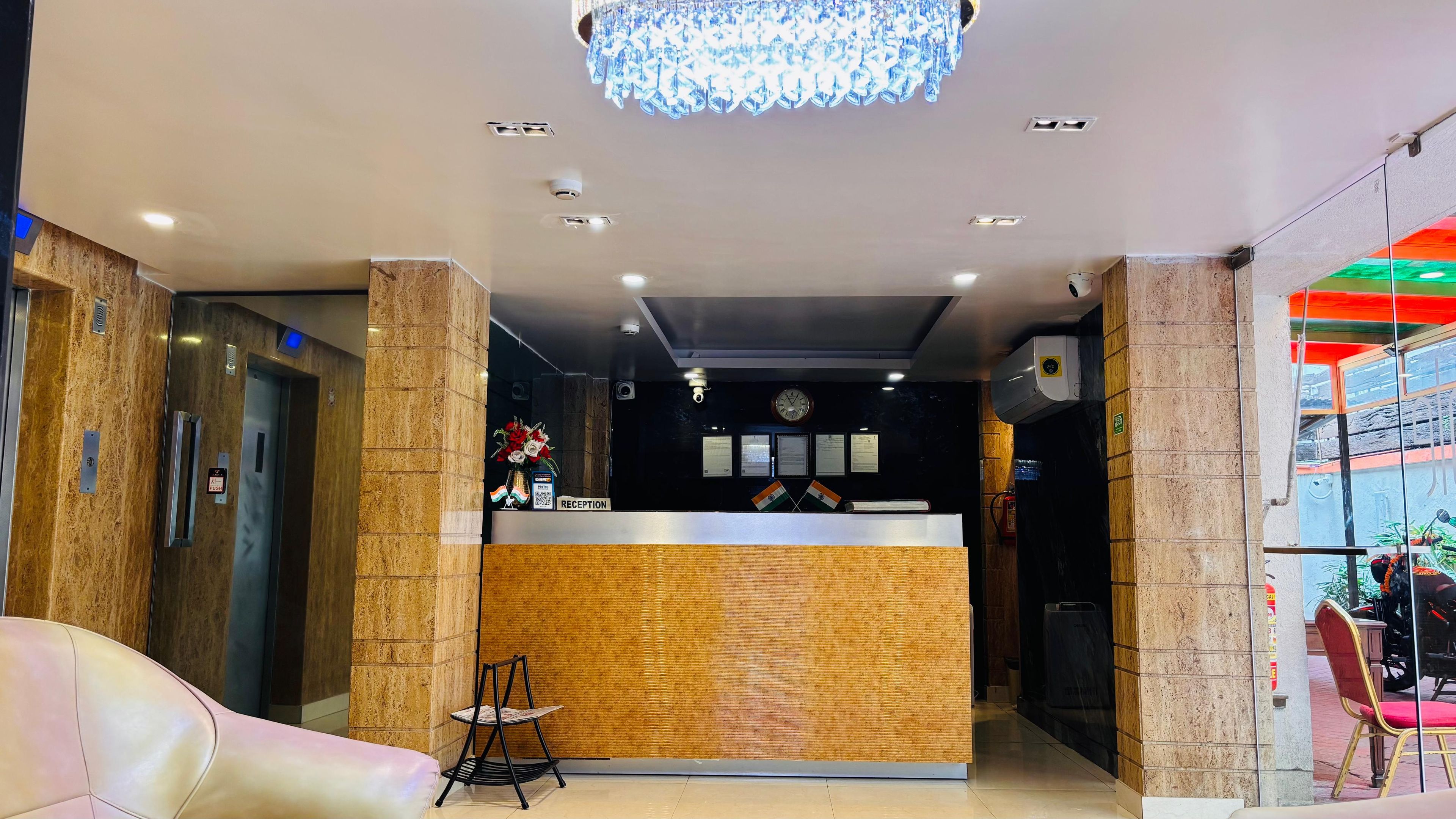A reception area with a reception desk, a clock, and a chandelier.