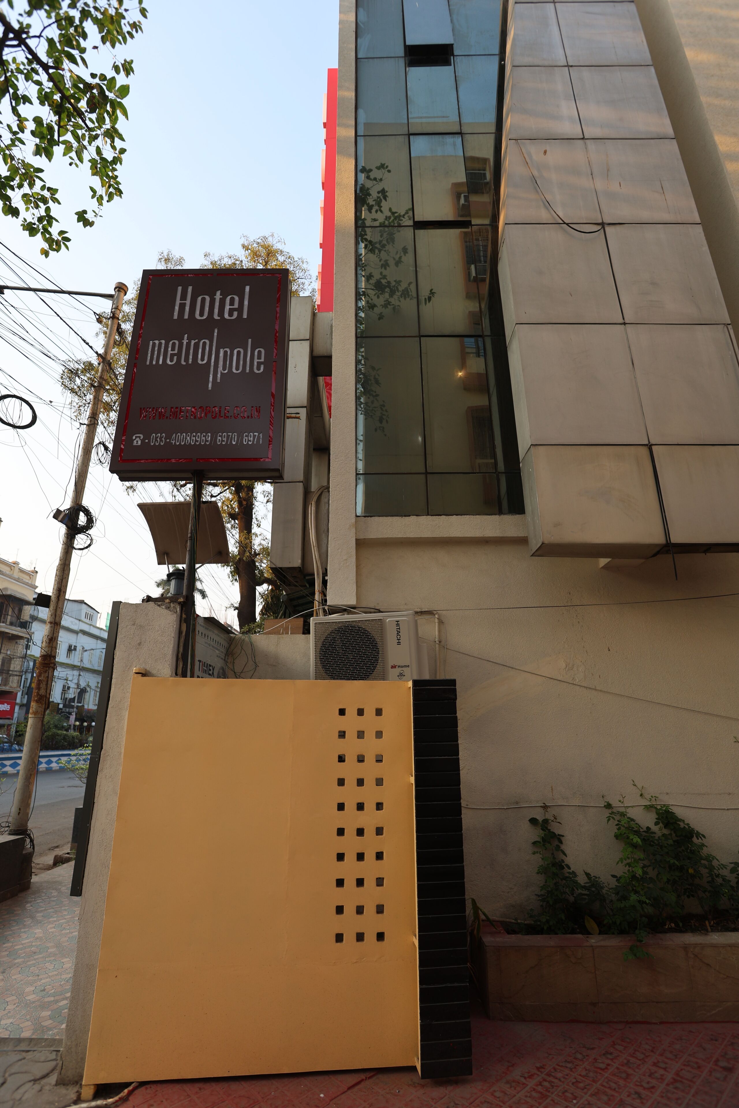 A hotel sign with the name "Hotel MetroPole" and a contact number.