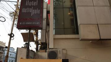 A hotel sign with the name "Hotel MetroPole" and a contact number.