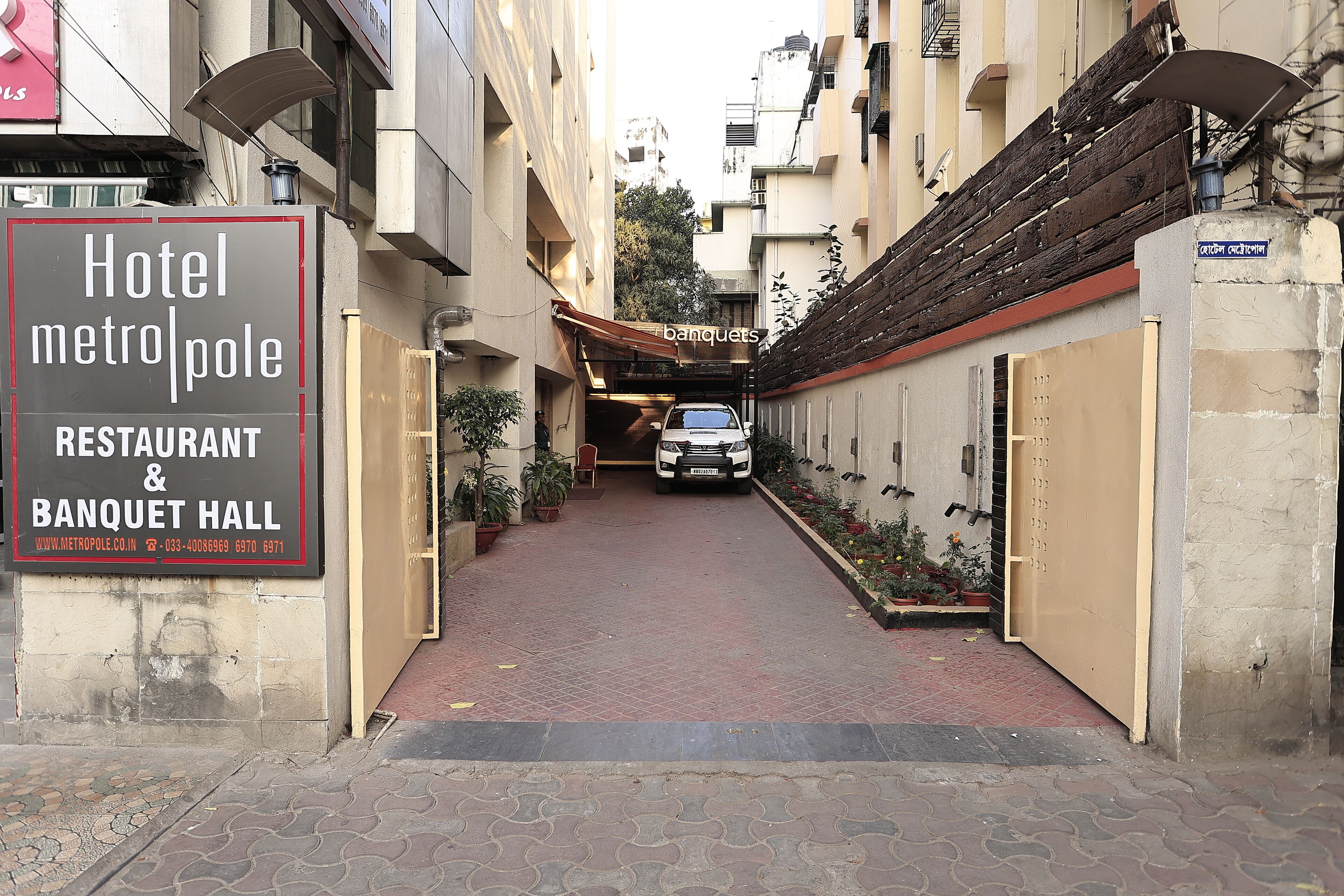 A narrow alleyway leading to a building with a sign for Hotel MetroPole, Restaurant & Banquet Hall.