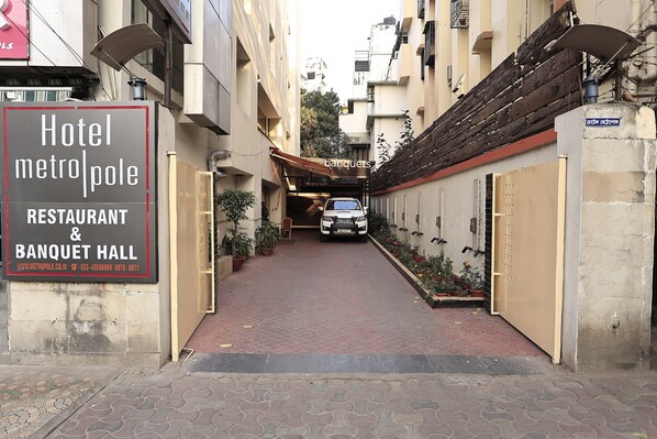 Un estrecho callejón que conduce a un edificio con un letrero que indica Hotel MetroPole, Restaurante y Salón de Banquetes.