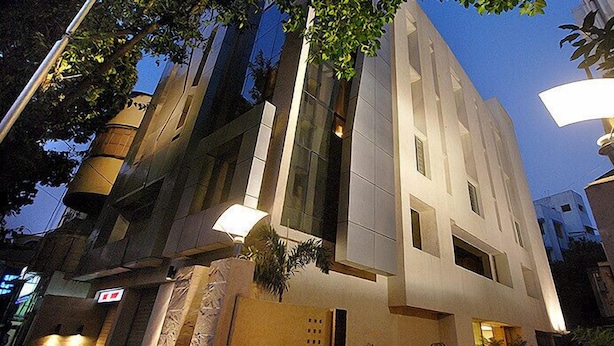 Un edificio moderno con fachada plana, ventanas amplias y una farola.
