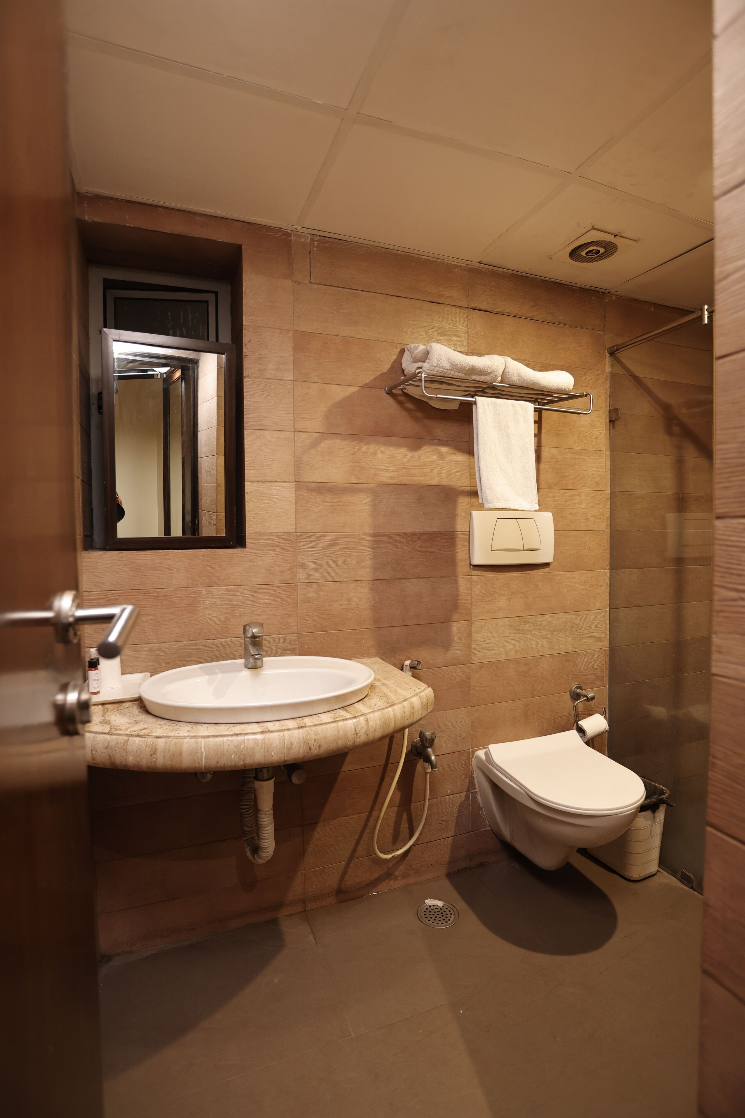 A compact bathroom with a sink, toilet, and shower.