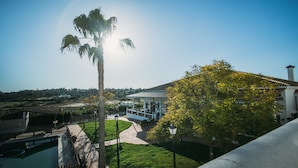 A building with a covered patio, a pathway, and a pool. - Hotel Valsequillo (Lepe)
