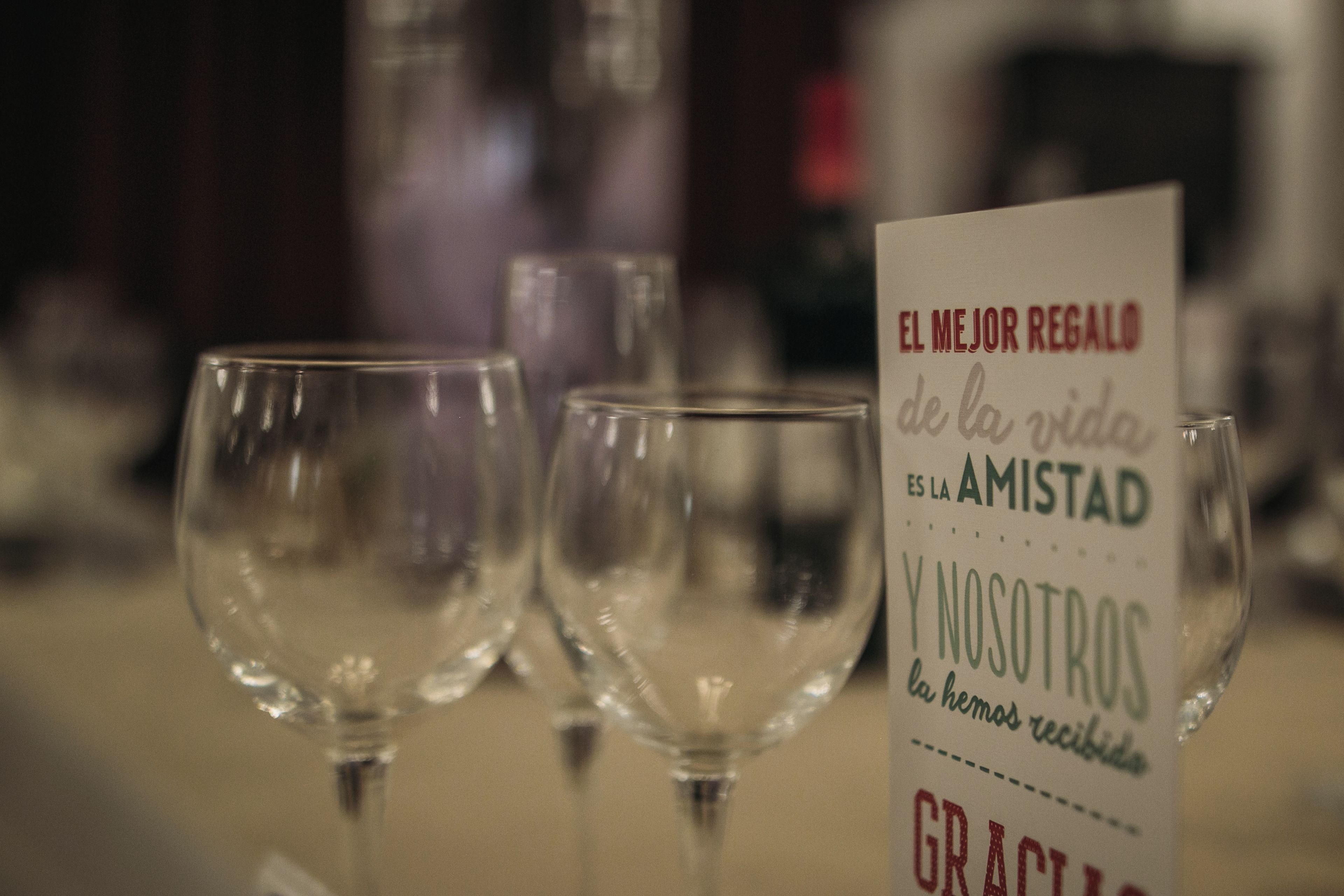 A table with empty wine glasses and a sign with text.