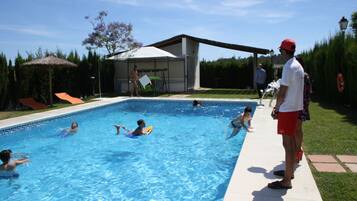 Una piscina con gente nadando y jugando.