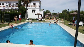 Relax by the rectangular pool surrounded by a tiled deck and lounge chairs.