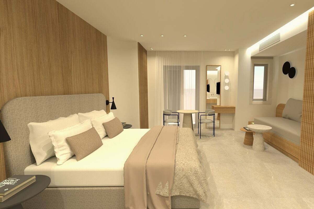 A modern hotel room with a large bed, a sofa, a TV, and a small dining area.