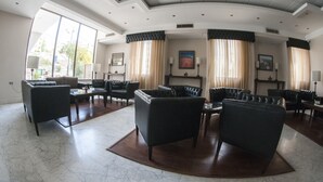 A spacious lobby with leather sofas, a marble floor, and large windows offering a view of the outdoors. - La Maison Hotel Petra (Wadi Musa)