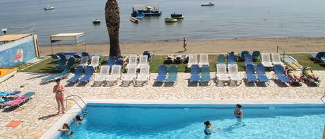 Una piscina techada, una piscina al aire libre, sombrillas