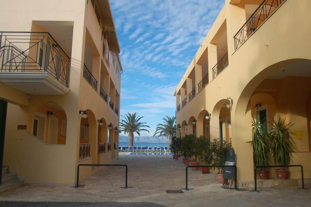 Un patio con piscina, plantas en macetas y vista al mar.