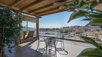 Un espacio de estar techado al aire libre con vista a un puerto y un paisaje urbano.