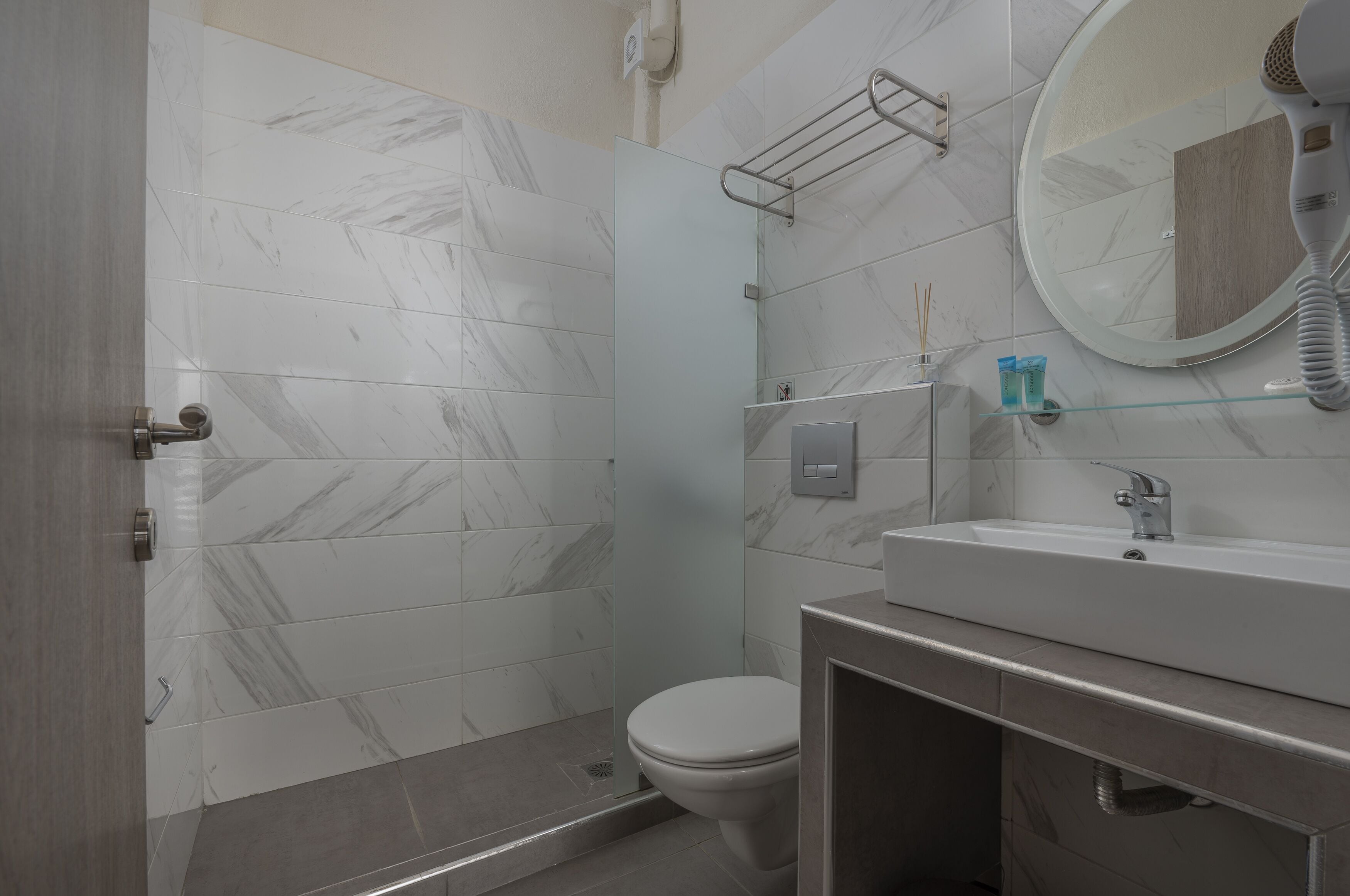 A modern bathroom with a shower, toilet, and sink.