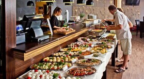 Una mesa de buffet con diferentes opciones de comida y una barra de servicio.