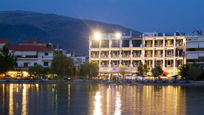 A multi-story hotel with balconies, outdoor seating, and a waterfront view. - Trokadero Hotel (Delphi)