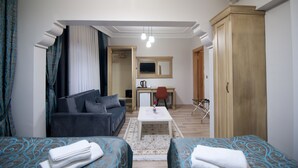 A hotel room with a sofa, a small desk, a chair, a wardrobe, and a bed. - Blue Tuana Hotel (Istanbul)