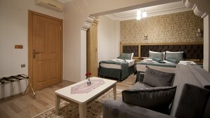 A hotel room with two beds, a sofa, a table, and a patterned wall. - Blue Tuana Hotel (Istanbul)