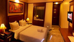 A hotel room with a large bed, bedside lamps, a TV, and a painting on the wall. - Madurai Residency (Madurai)