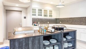 A modern kitchen with a buffet setup, including a toaster, a food display, and a coffee station. - Homewood Suites by Hilton Leesburg (Leesburg)