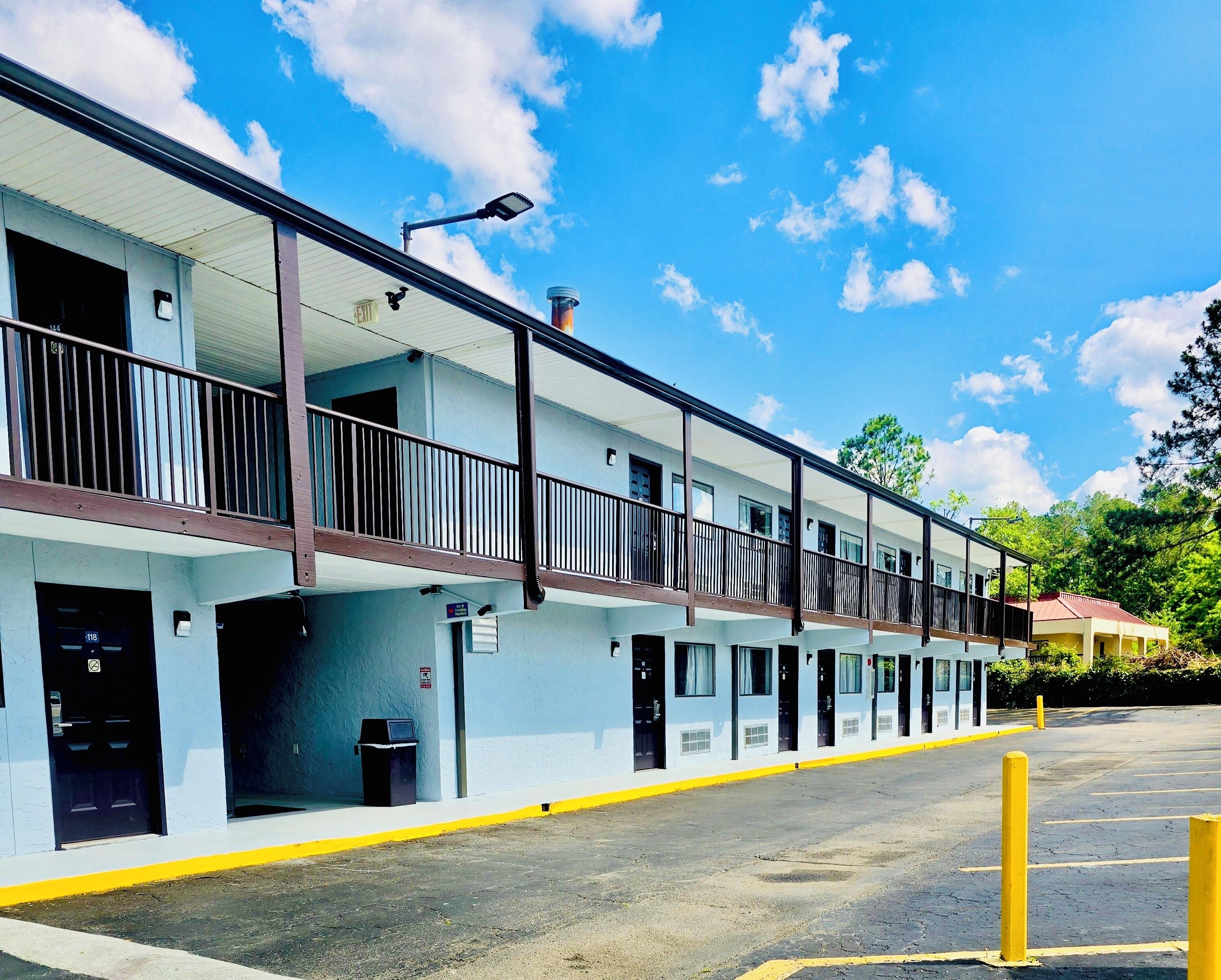 A motel with a two-story structure, multiple rooms, and a parking area.
