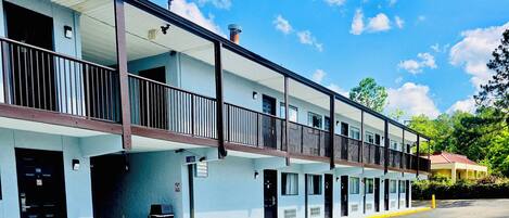 A motel with a two-story structure, multiple rooms, and a parking area.