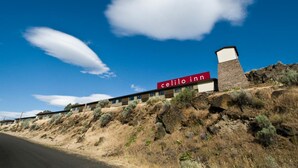 A hotel named 'celilo inn' with a modern design, situated on a hillside with a clear blue sky and sparse vegetation. - Celilo Inn (The Dalles)