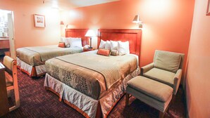A hotel room with two beds, a chair, a desk, and a lamp. - Heritage Inn La Mesa (La Mesa)