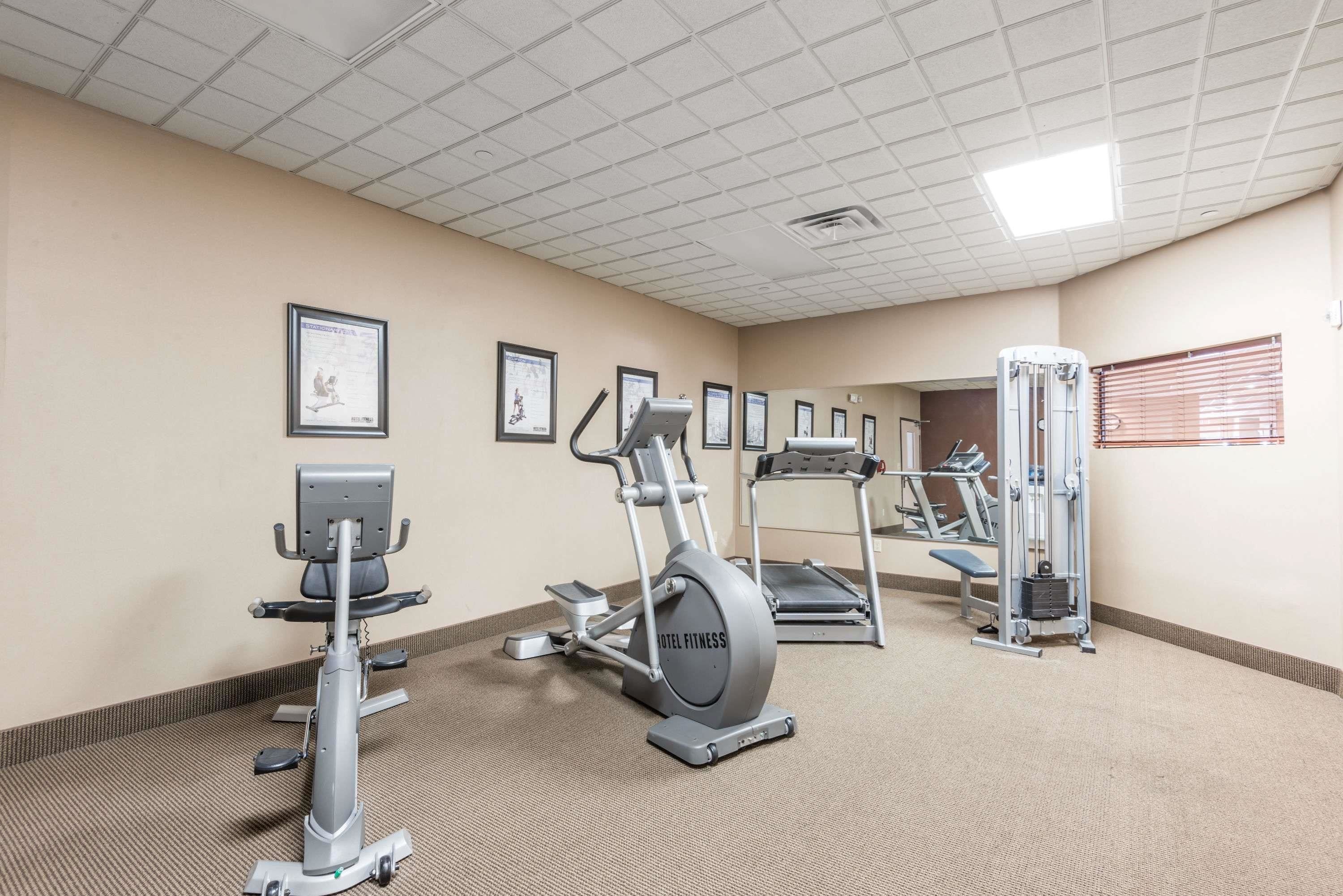 A hotel fitness center with cardio machines, a treadmill, and a weight machine.