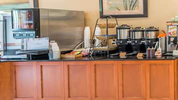 A coffee station with a coffee machine, a beverage dispenser, and a coffee cart.