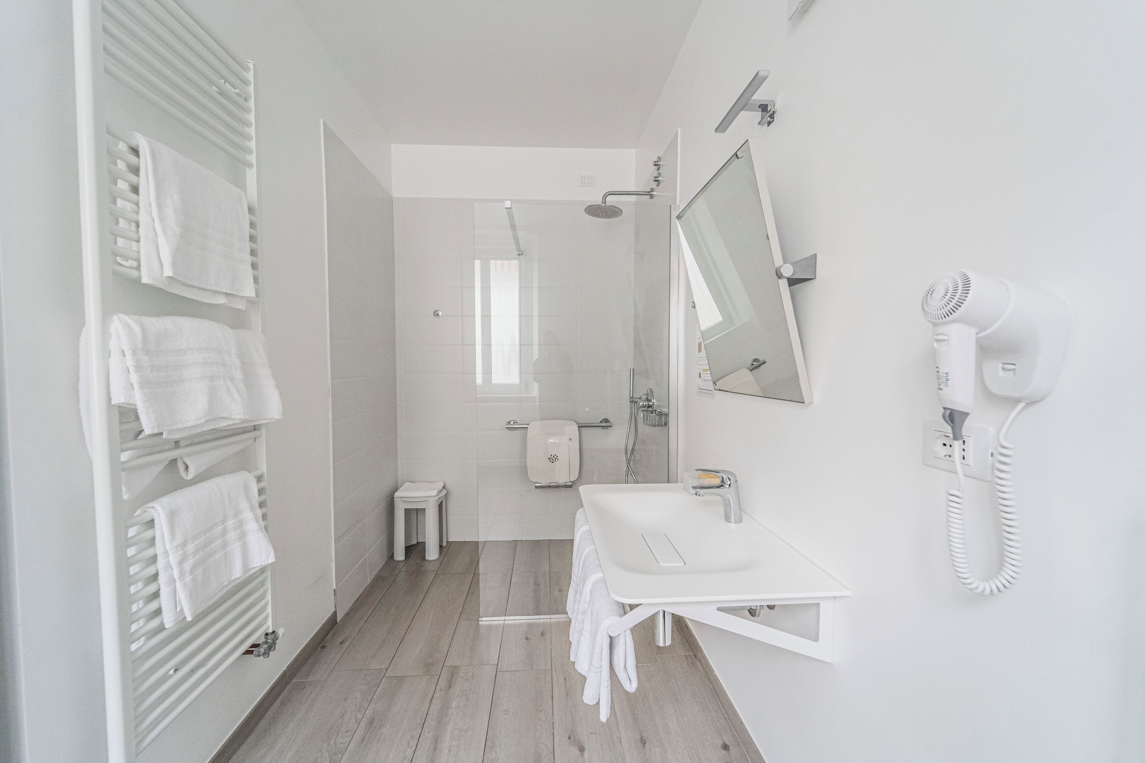 A modern bathroom with a shower, toilet, and sink.