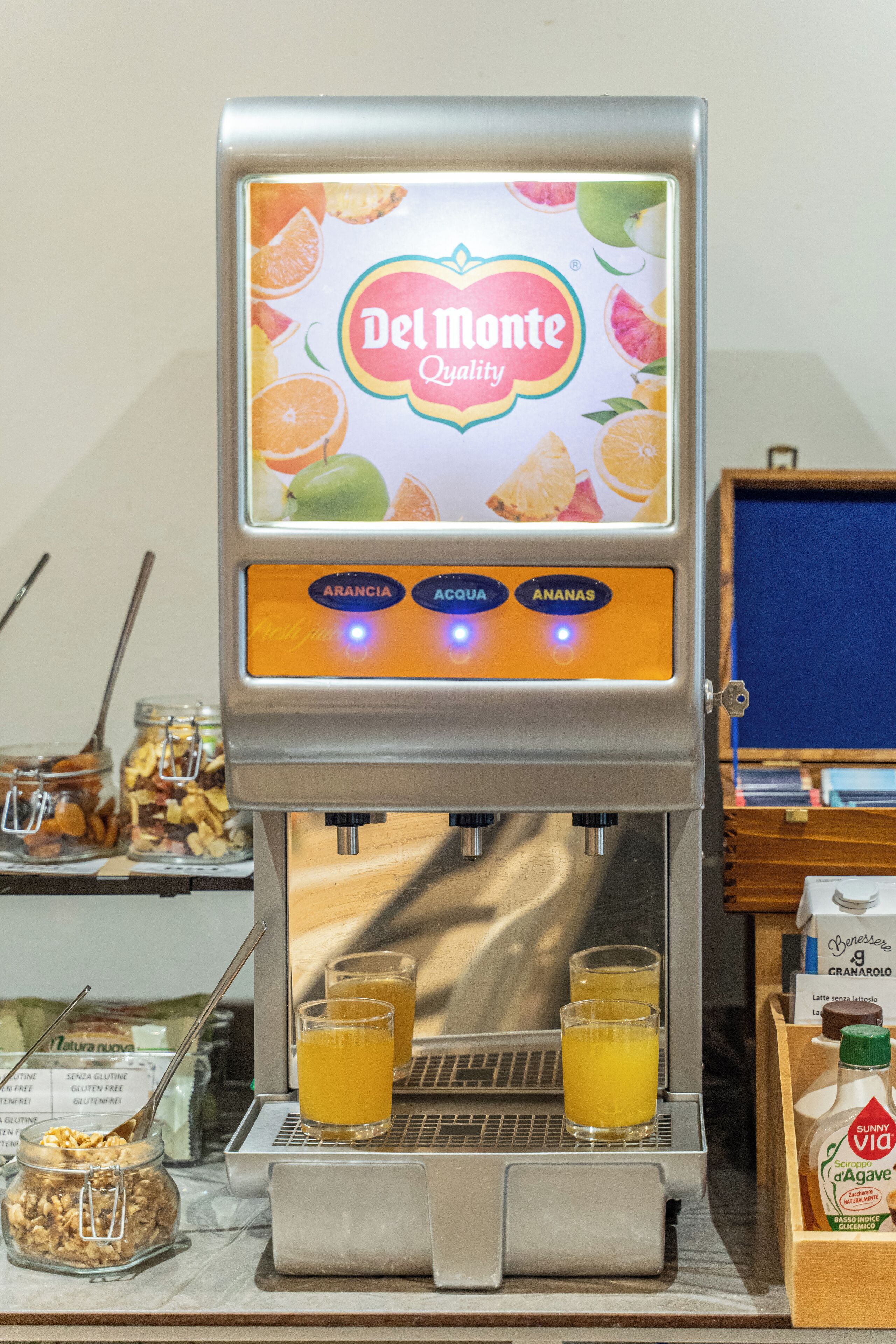 Erogatore di succo Del Monte Quality con opzioni per succo d'arancia, di mela e di banana.