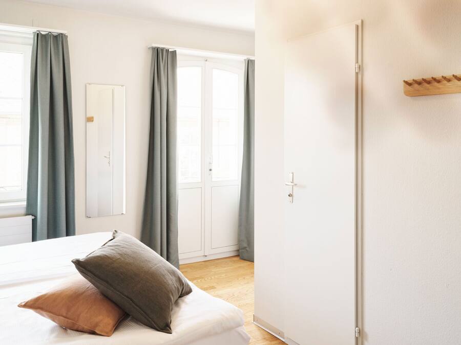 Un dormitorio con cama, armario y puerta.