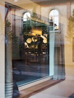 A restaurant with brick walls, large windows, and hanging paper lanterns.