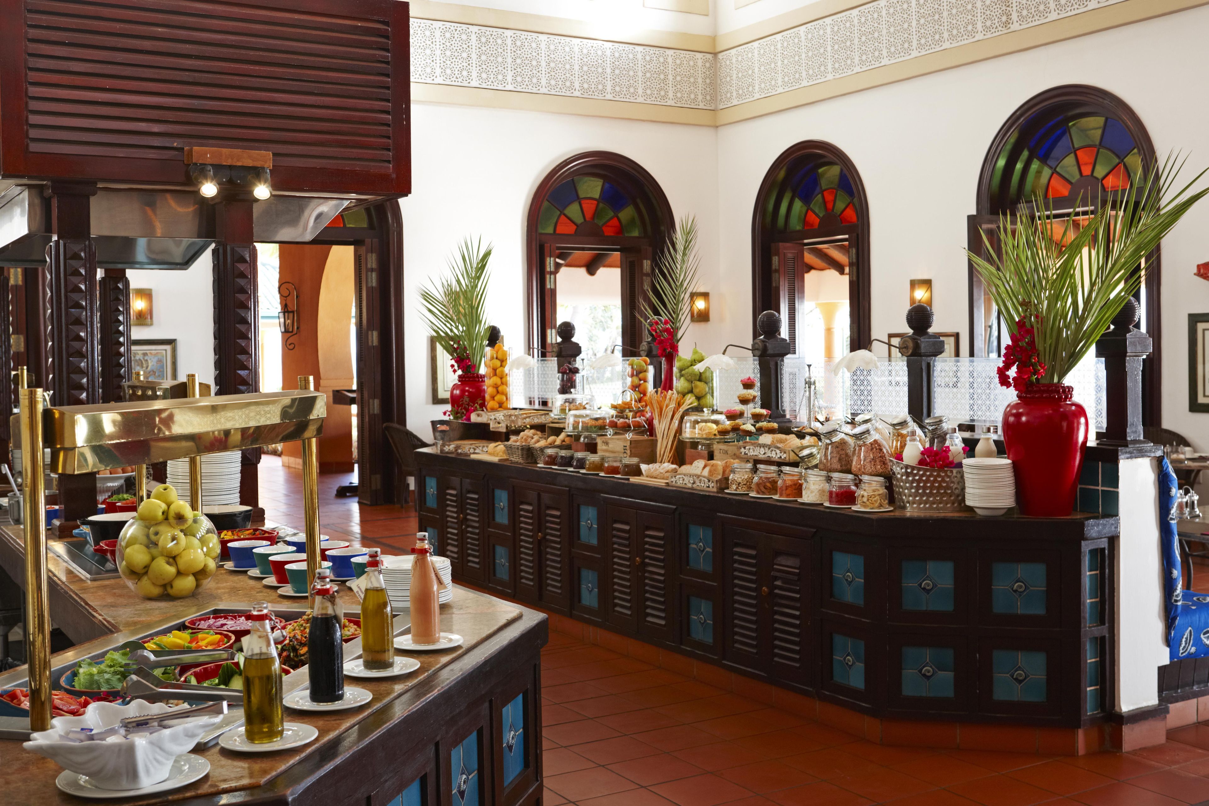 A buffet area with various food items and a decorative plant.
