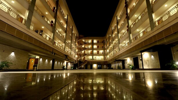 Un hotel de varios pisos con un atrio central, balcones en cada planta y un suelo pulido y reflectante.