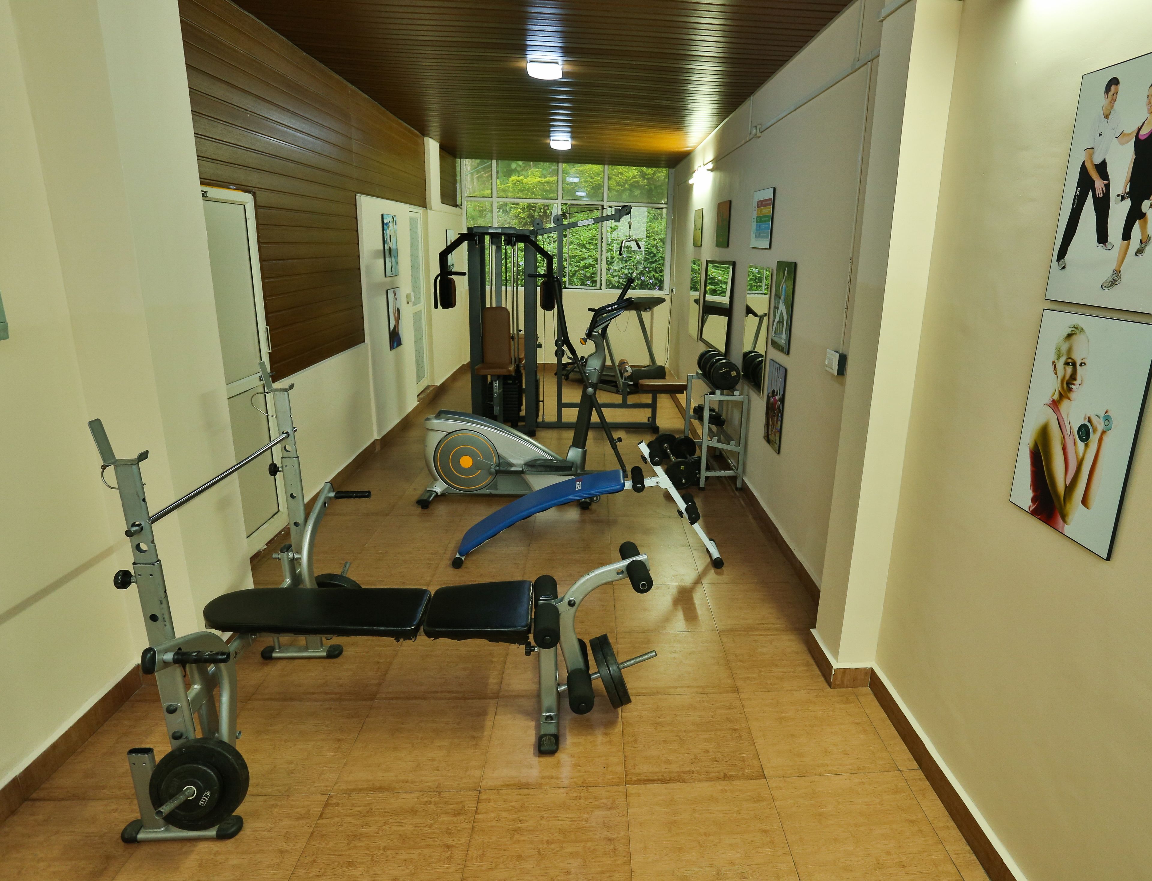 Ein Fitnessstudio mit verschiedenen Trainingsgeräten, darunter Laufband, Ergometer und Kraftmaschinen.