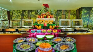 Un bufé con diversos alimentos y una pieza decorativa central.