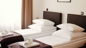 A hotel room with a large bed, two bedside tables, a chandelier, and a framed picture on the wall. - Hotel Eden (Kraków)