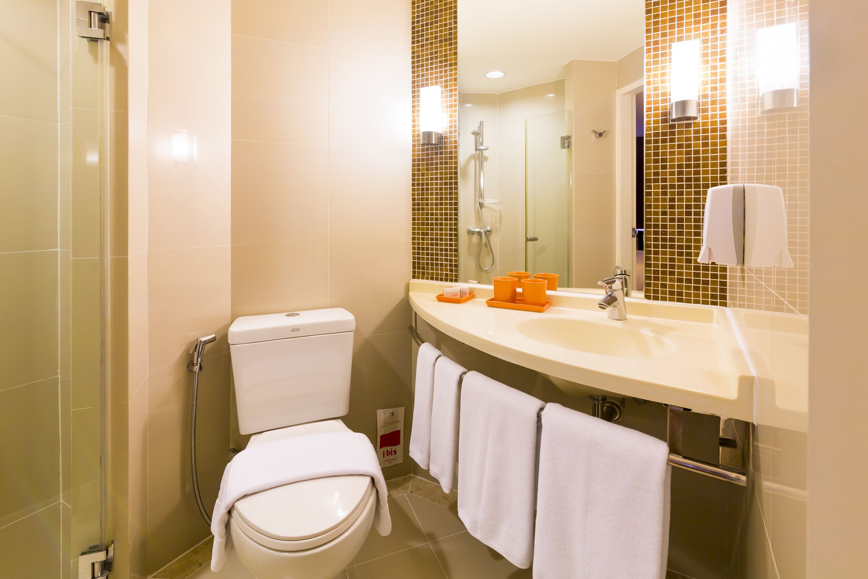 A modern bathroom with a toilet, shower, and sink.