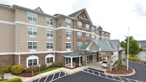A Country Inn & Suites building with a brick facade, multiple windows, and a covered entrance area.
