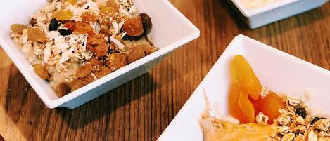 A table with multiple square white dishes containing various breakfast items.