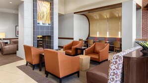 A modern lobby with leather seating, a fireplace, and a patterned wall. - Hyatt Place Memphis/Germantown (Memphis)
