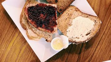 A breakfast plate with toast, jam, butter, and a cup of coffee.