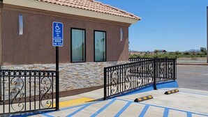 A building with a parking sign indicating a minimum fine of $250 for unauthorized parking. - Magnuson Hotel Blythe (Blythe)