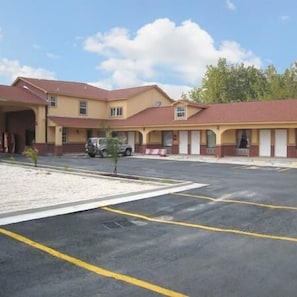 A two-story motel with a parking lot in front.