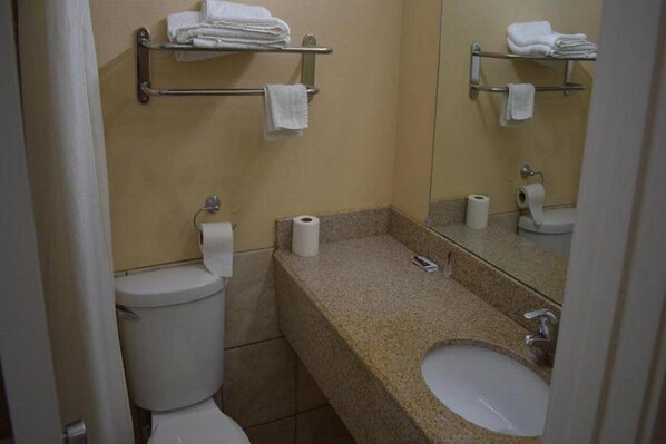 Ein Badezimmer mit Toilette, Waschbecken und Handtuchhaltern.