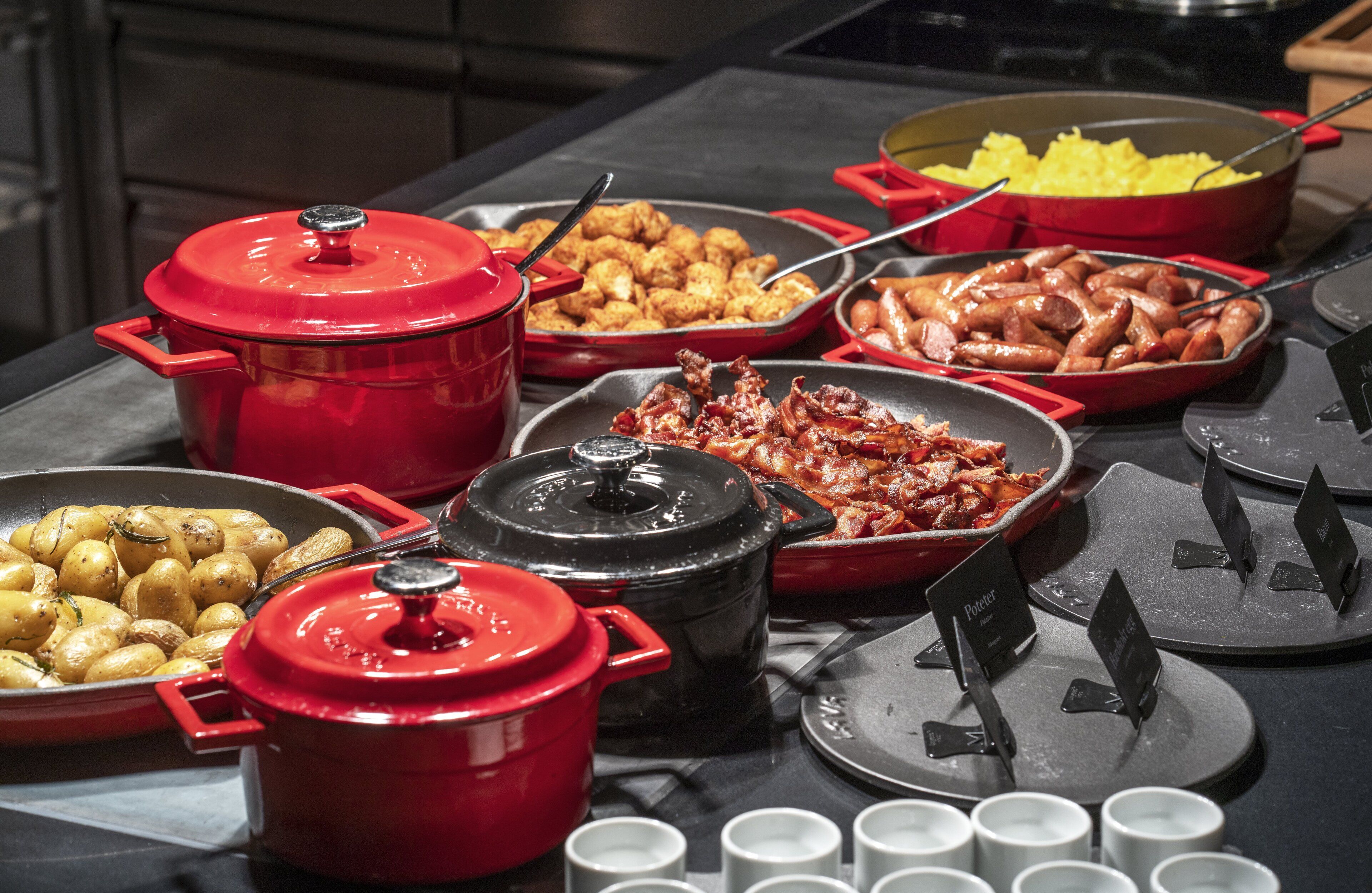 A buffet with various dishes and cooking pots.